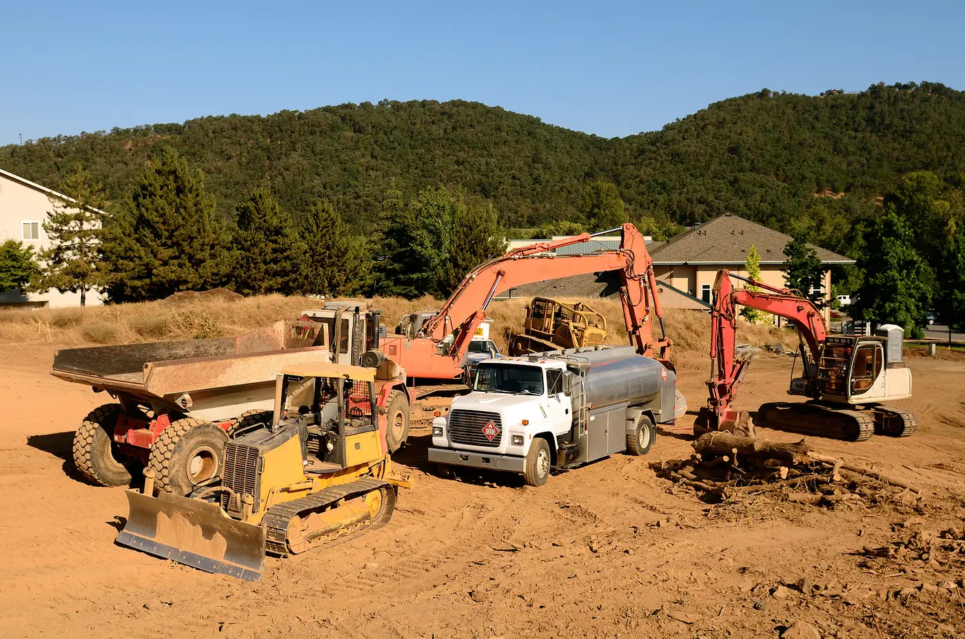 Fuel truck refueling earthmoving equipment on a construction site