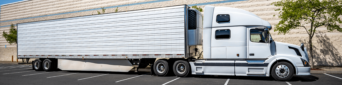 Refrigerated trailer with its reefer unit coupled to a white semi tractor