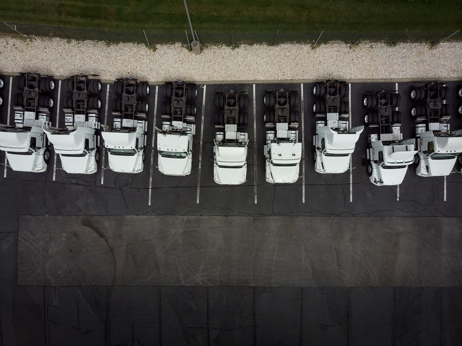 Aerial view of semi-truck tractors parked in a row at a logistics yard