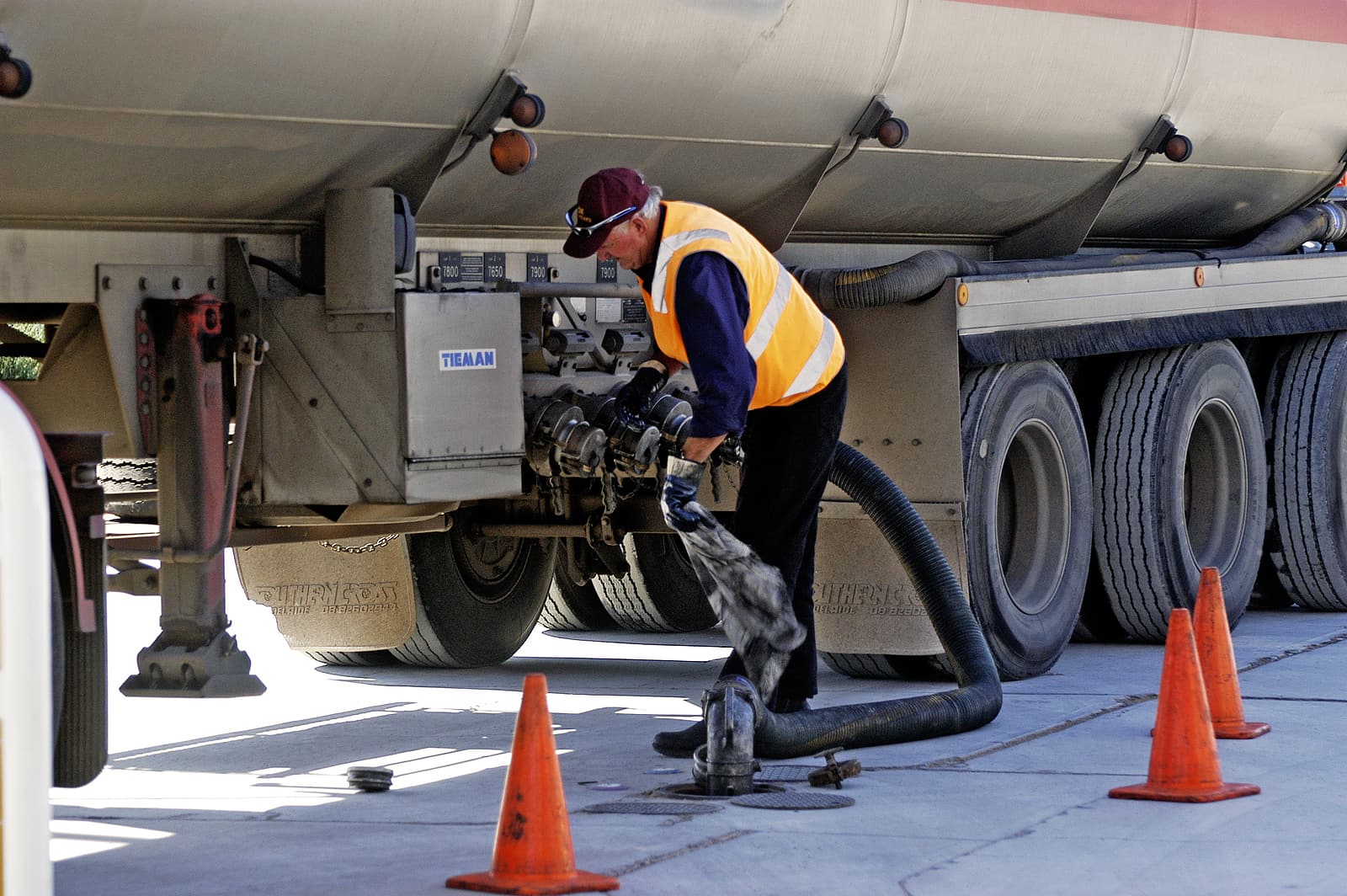 Driver connecting a fuel hose for mobile fleet fueling at a commercial yard